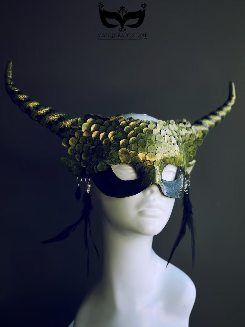 Green dragon horn masquerade mask with emerald scales, long horns, and feather accents, designed as a fantasy headdress.