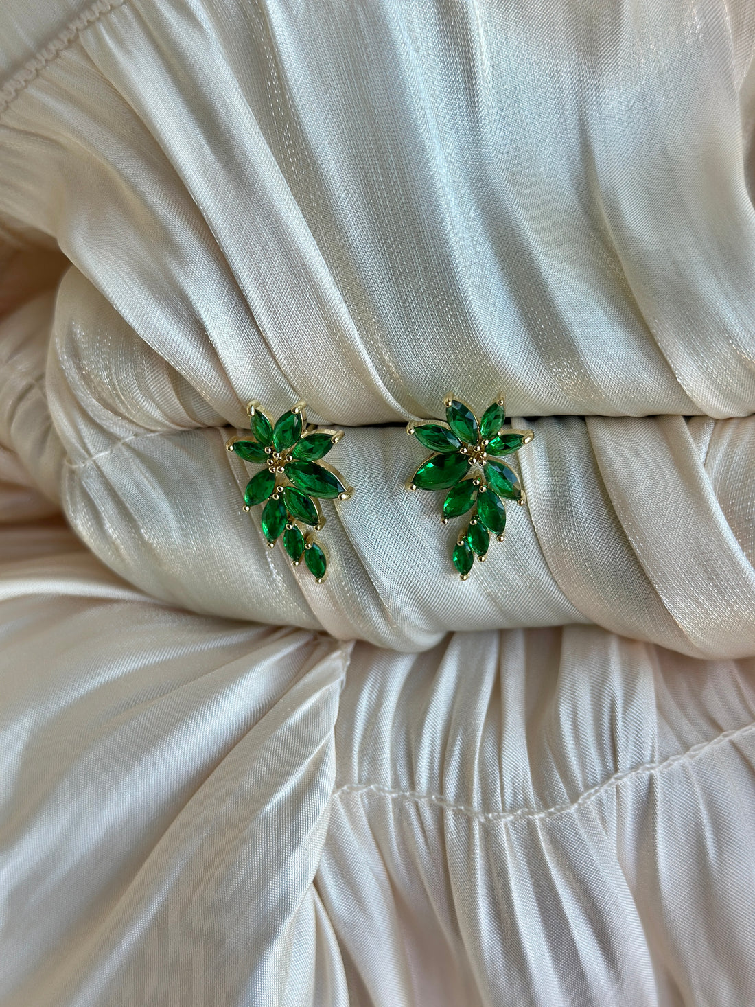 Emerald green earrings with marquise-cut crystals in a floral-inspired design.