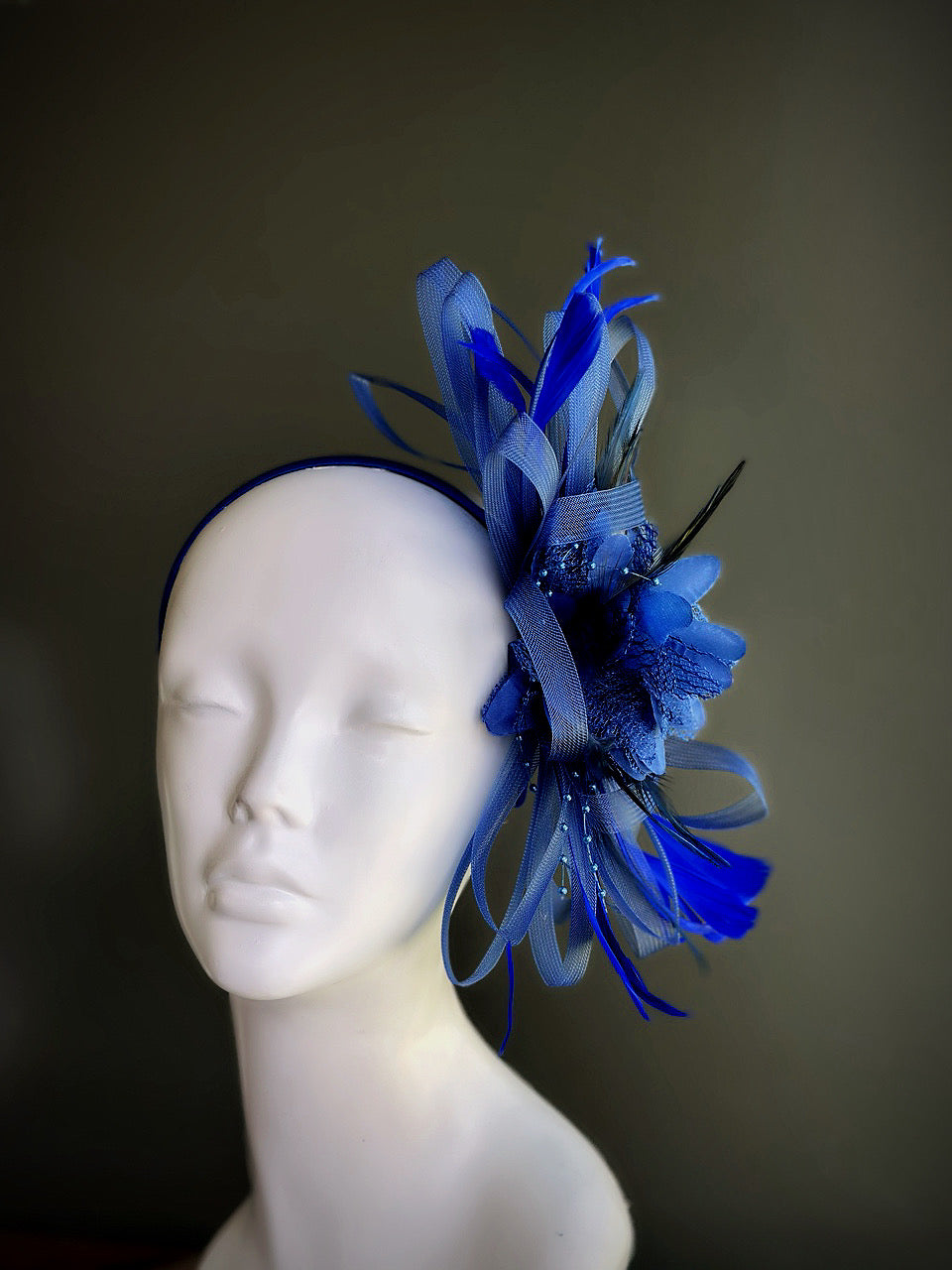 Blue feather and tulle fascinator hat with floral accents and beaded detailing