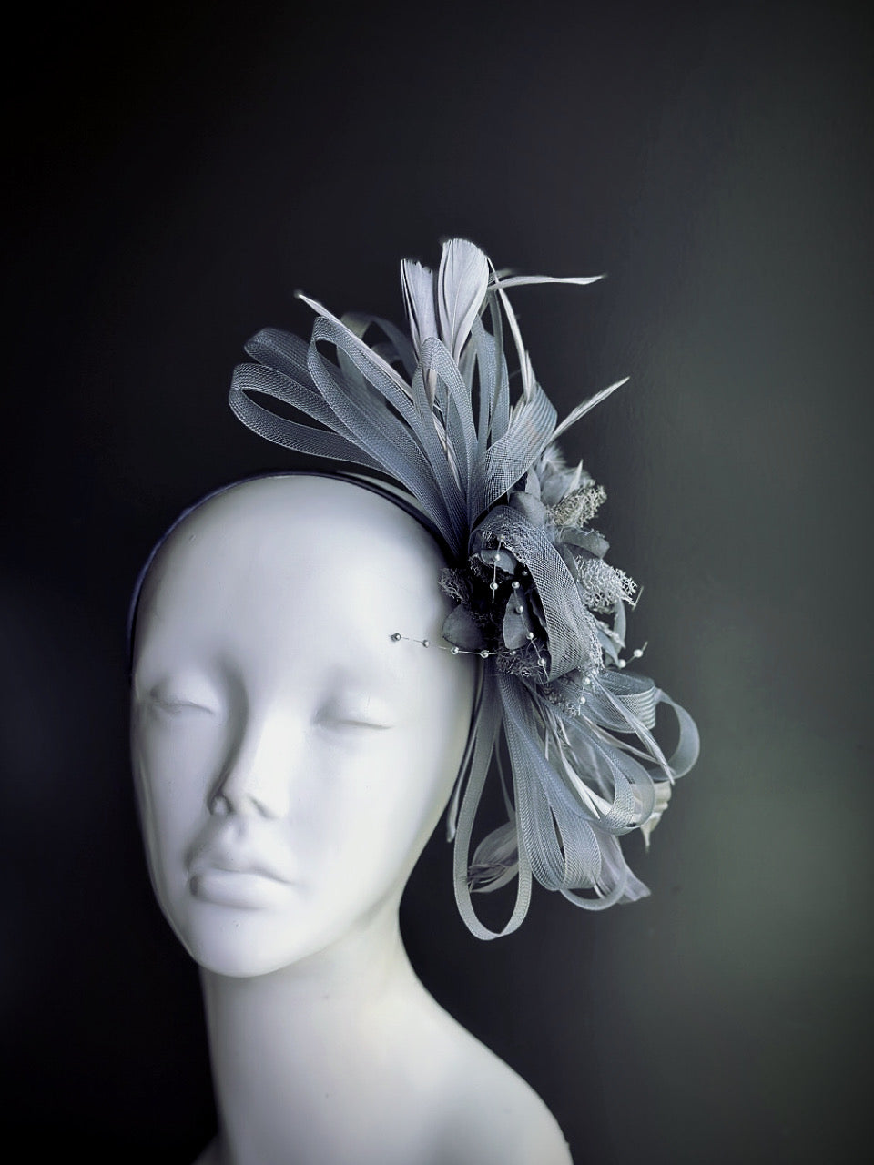 Dark gray feather and tulle fascinator hat with floral center and curled accents