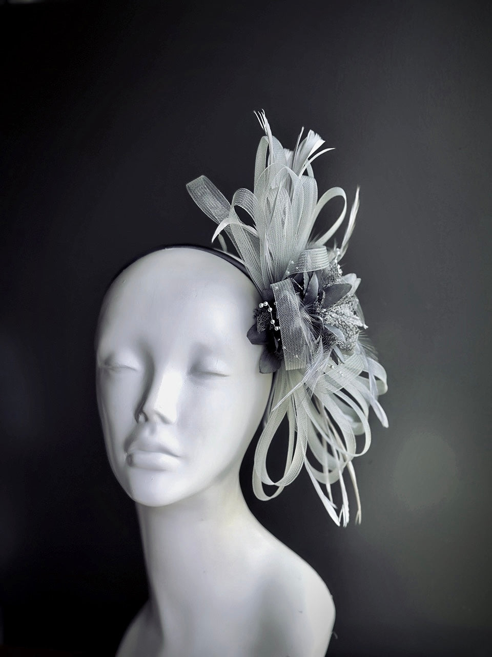 light gray fascinator hat with curled feathers and sheer tulle detail