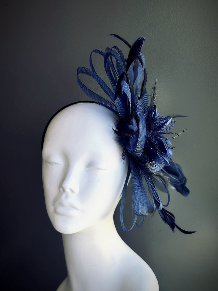 Navy blue fascinator hat with feather and tulle loops on headband