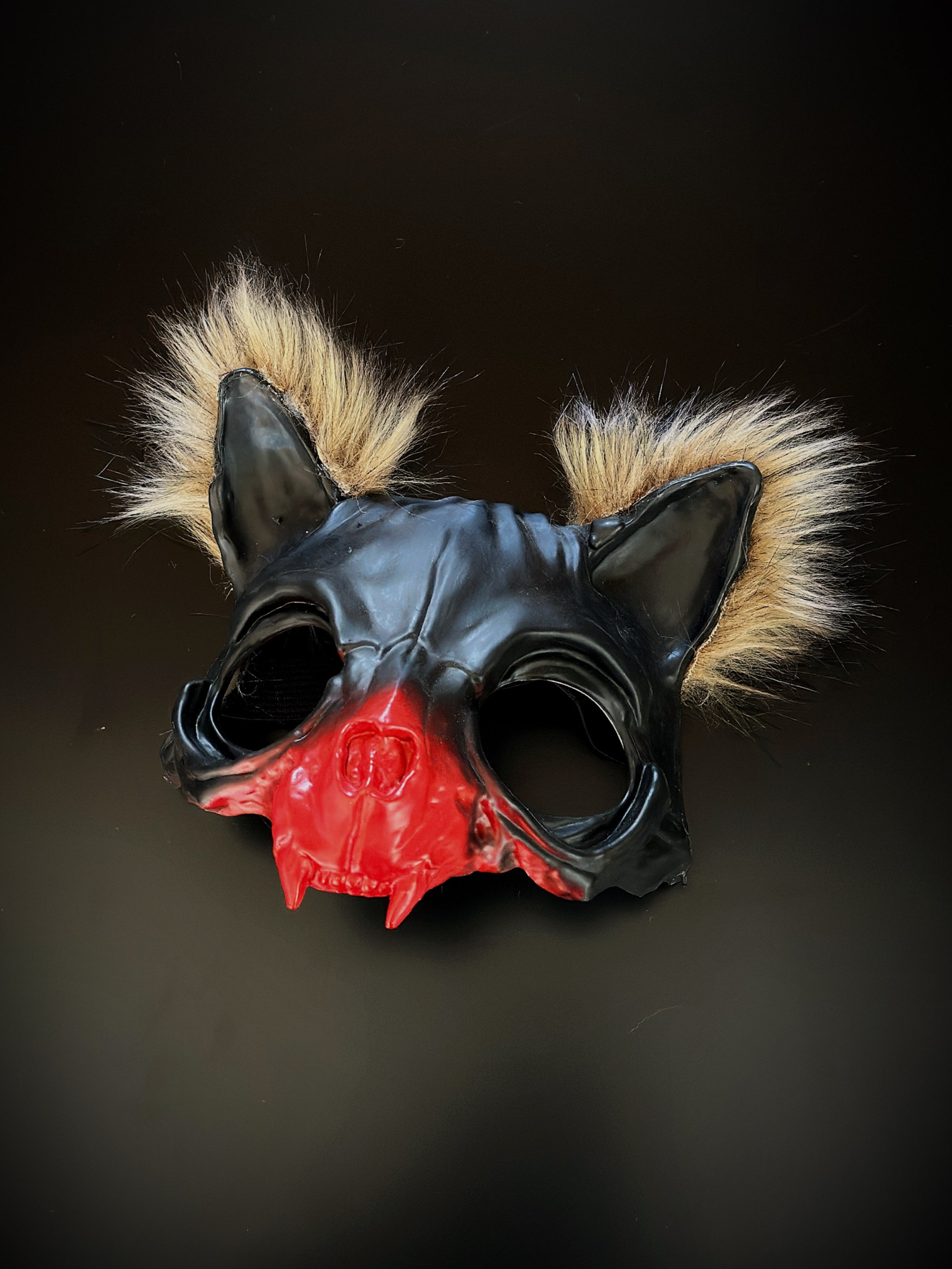 Black cat skull mask with red accents and fur tufts for cosplay and therian enthusiasts.