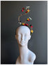 Artistic floral branch fascinator headband with flowers and birds.