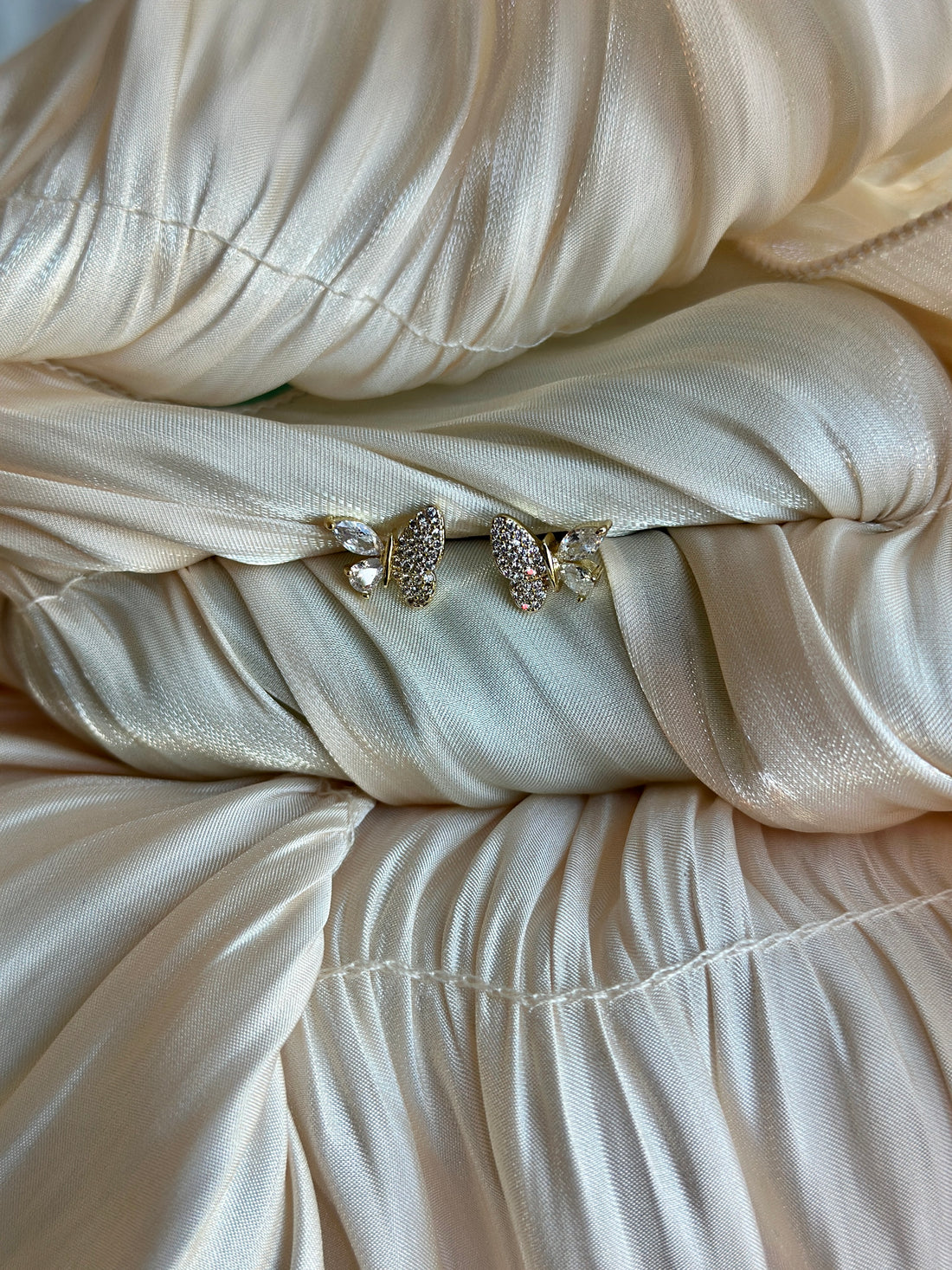 Earrings with crystal-studded butterfly wings and marquise-cut accents.