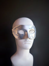Silver mask with blue glitter swirl accents, featuring a frosted and sophisticated design for elegant occasions.