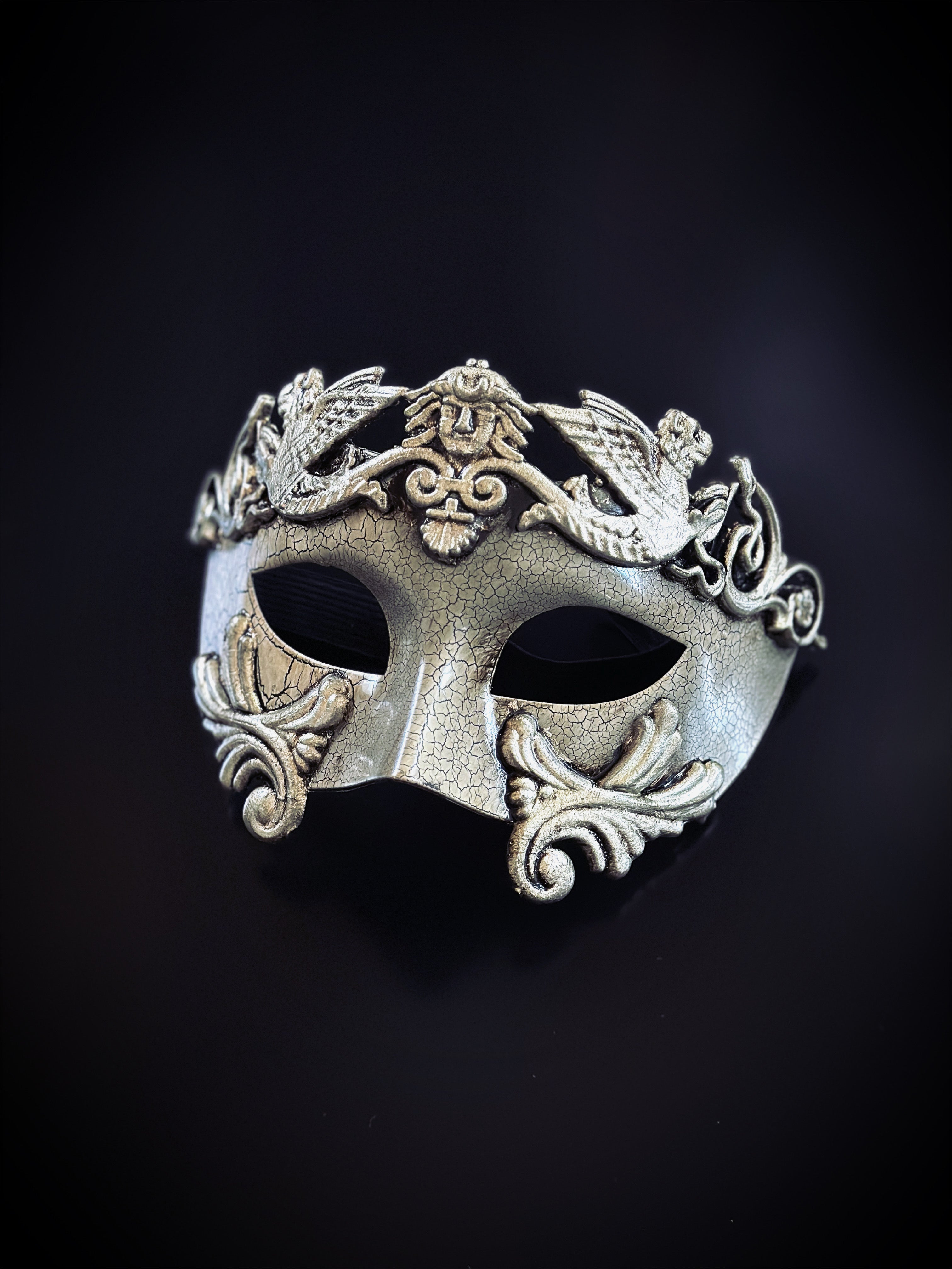 Silver gladiator mask with crackle texture, lion crest, and ornate scroll details for masquerade or costume wear.