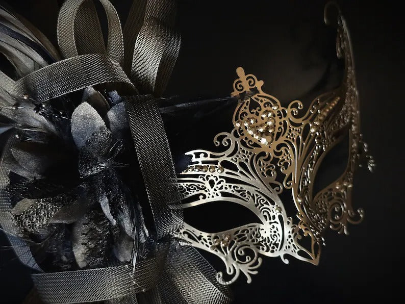 Elegant gold and black masquerade mask with feathers and filigree lace metal, perfect for balls, proms, and Venetian carnival events.