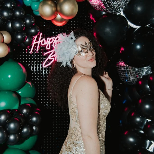 Elegant gold filigree mask with crystal accents and grey feathers, ideal for masquerade balls, weddings, or prom.