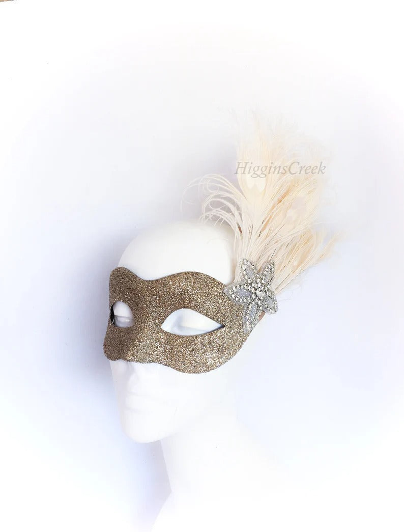 Elegant gold glitter mask with feathers and rhinestones for weddings, masquerade balls, and proms.