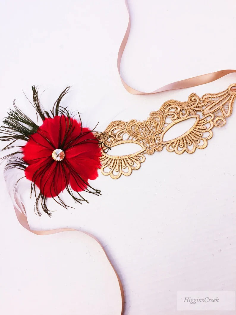 Elegant gold lace masquerade mask with red feathers and rhinestone accent for women’s prom, Mardi Gras, and costume events.