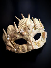 Gold masquerade mask with seashells, pearls, and mermaid-inspired starfish details.