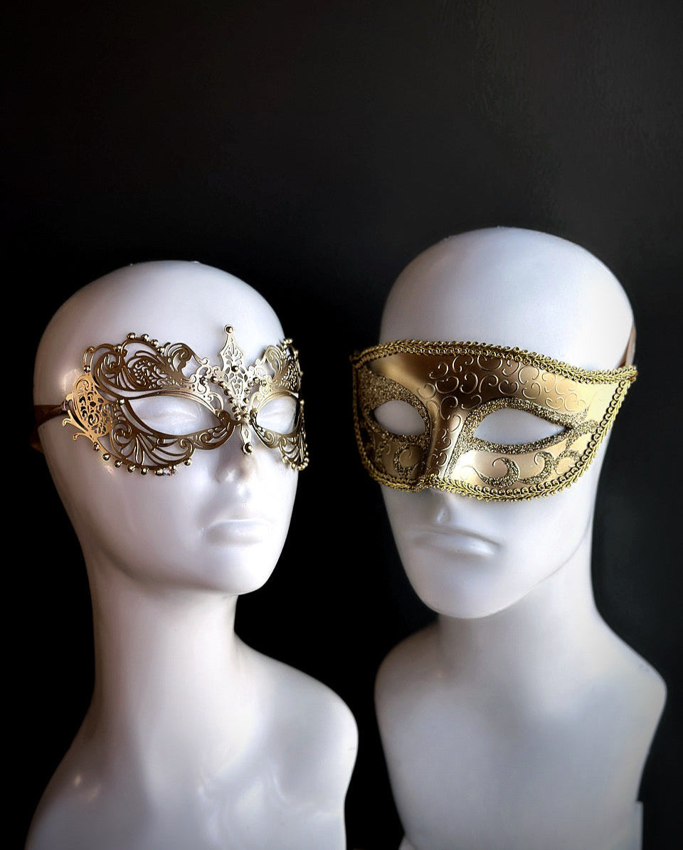 Elegant gold Venetian couples mask set with a filigree mask for her and an embossed mask for him, perfect for masquerade balls and weddings.