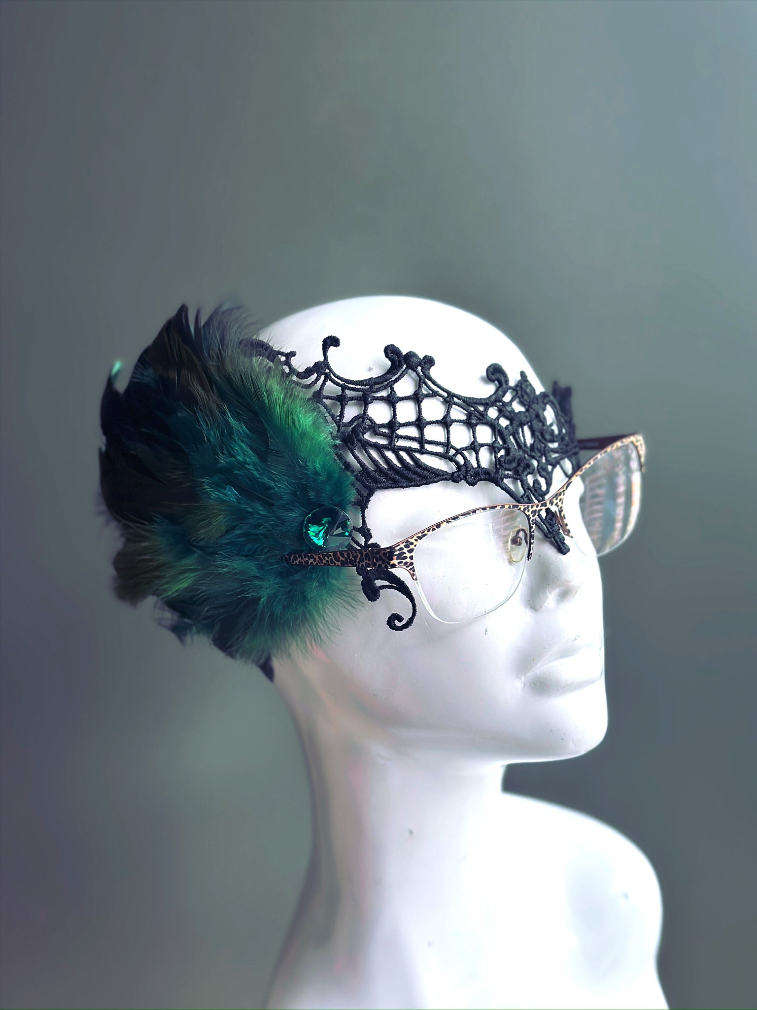 Green Feather Masquerade Mask with black lace, designed to fit over glasses, adorned with lush green feathers.