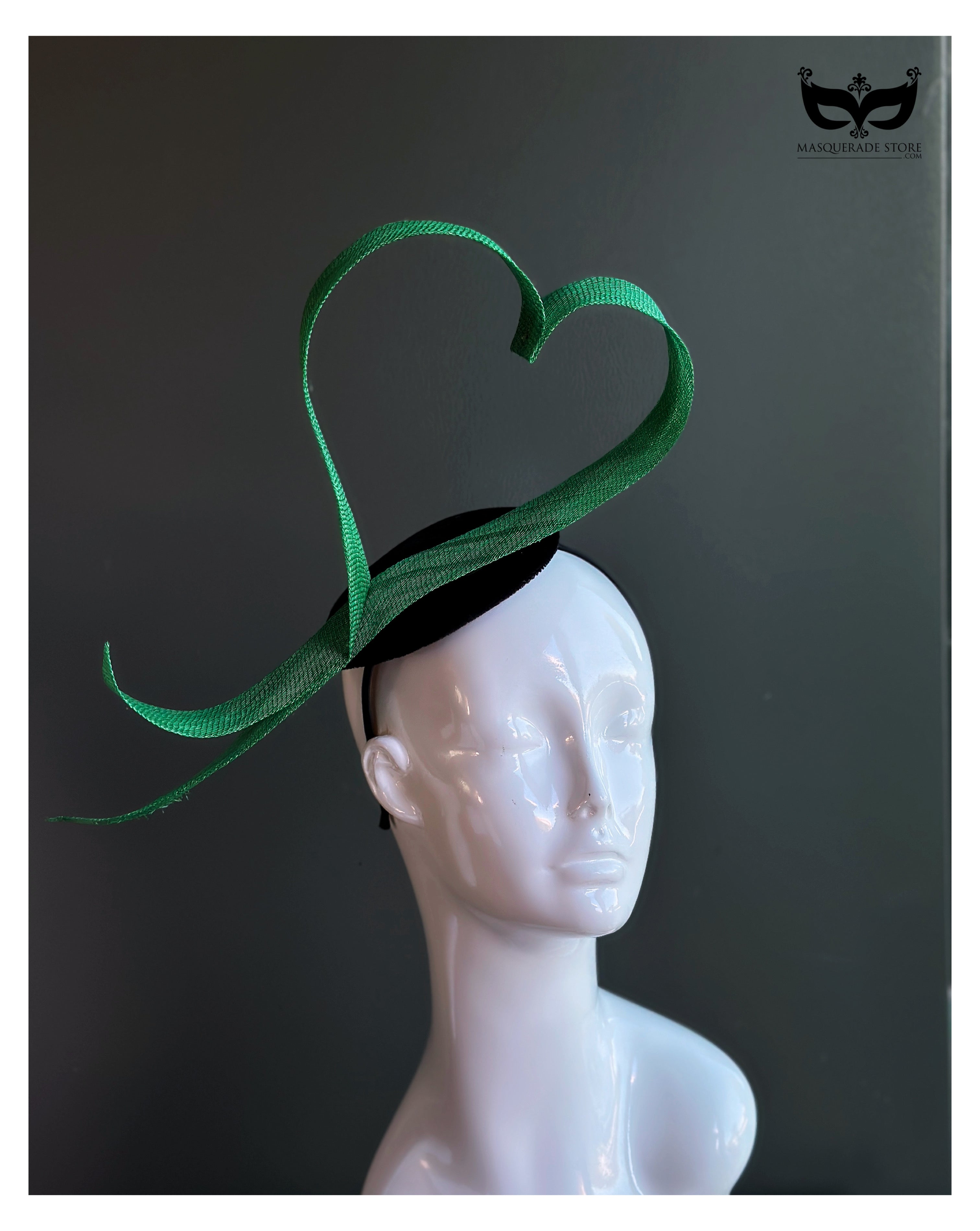 Green heart loop fascinator headband with sculptural ribbon design on mannequin