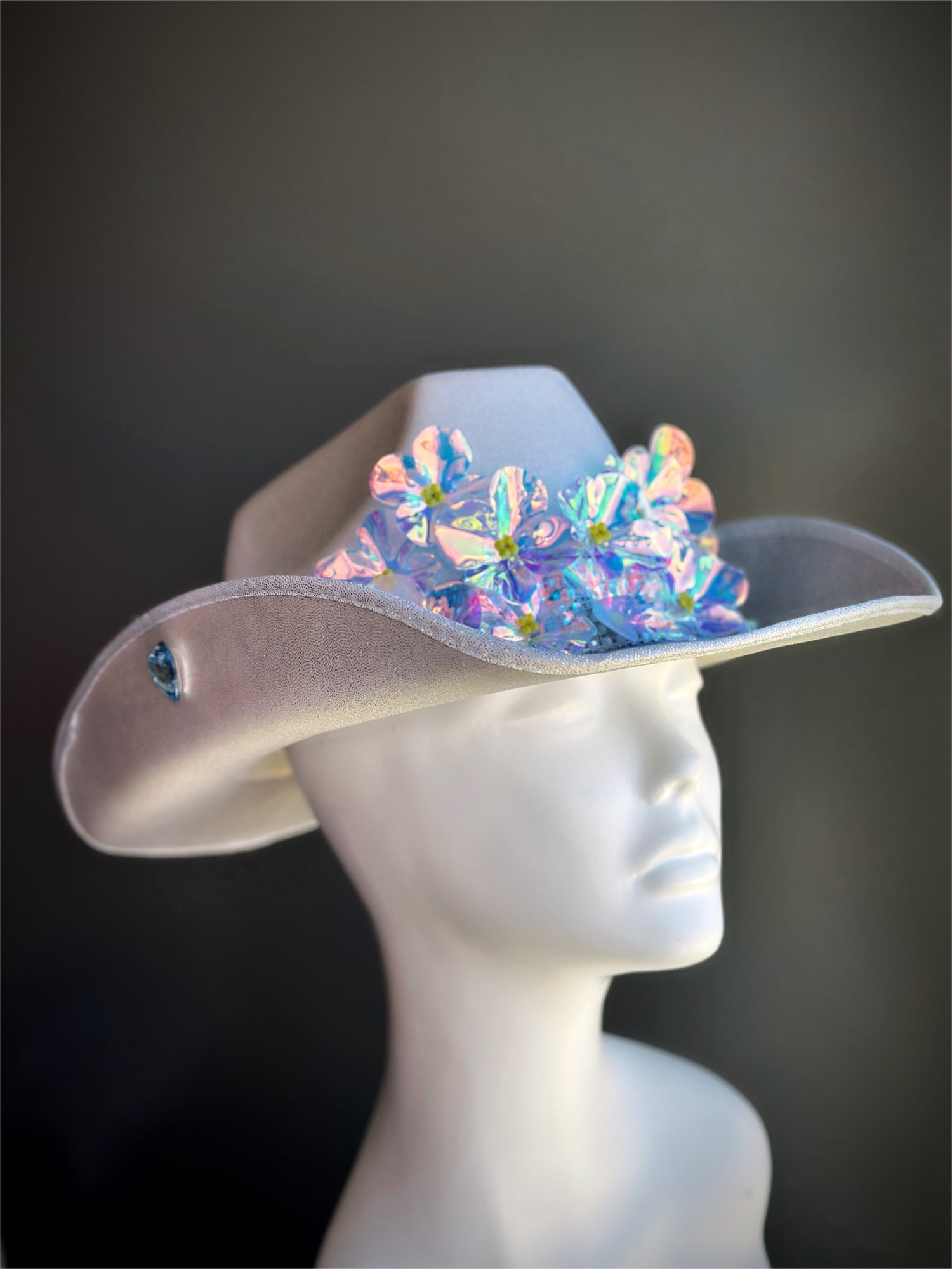 Silver cowgirl hat with iridescent flower embellishments and rhinestone trim.