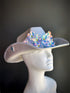 Silver cowgirl hat with iridescent flower embellishments and rhinestone trim.