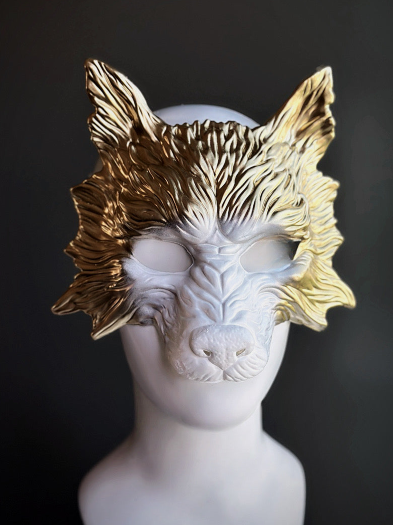 Wolf masquerade mask in gold with white in the center.