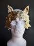 Wolf masquerade mask in gold with white in the center.