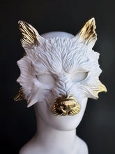 Wolf masquerade mask in white with golden ears and snout.