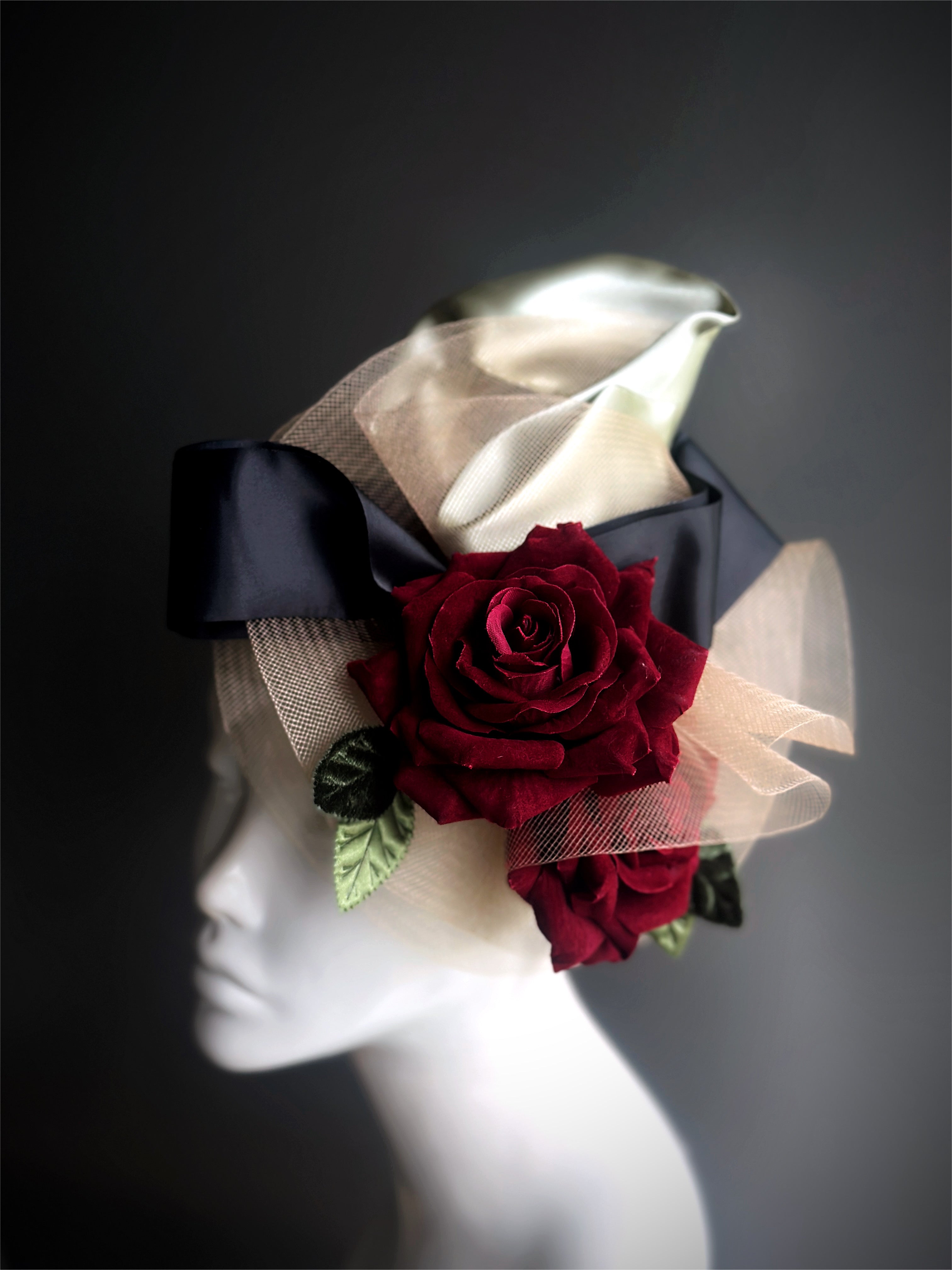 Red rose fascinator with a bold black bow and gold tulle accents, ideal for weddings, galas, or sophisticated occasions.
