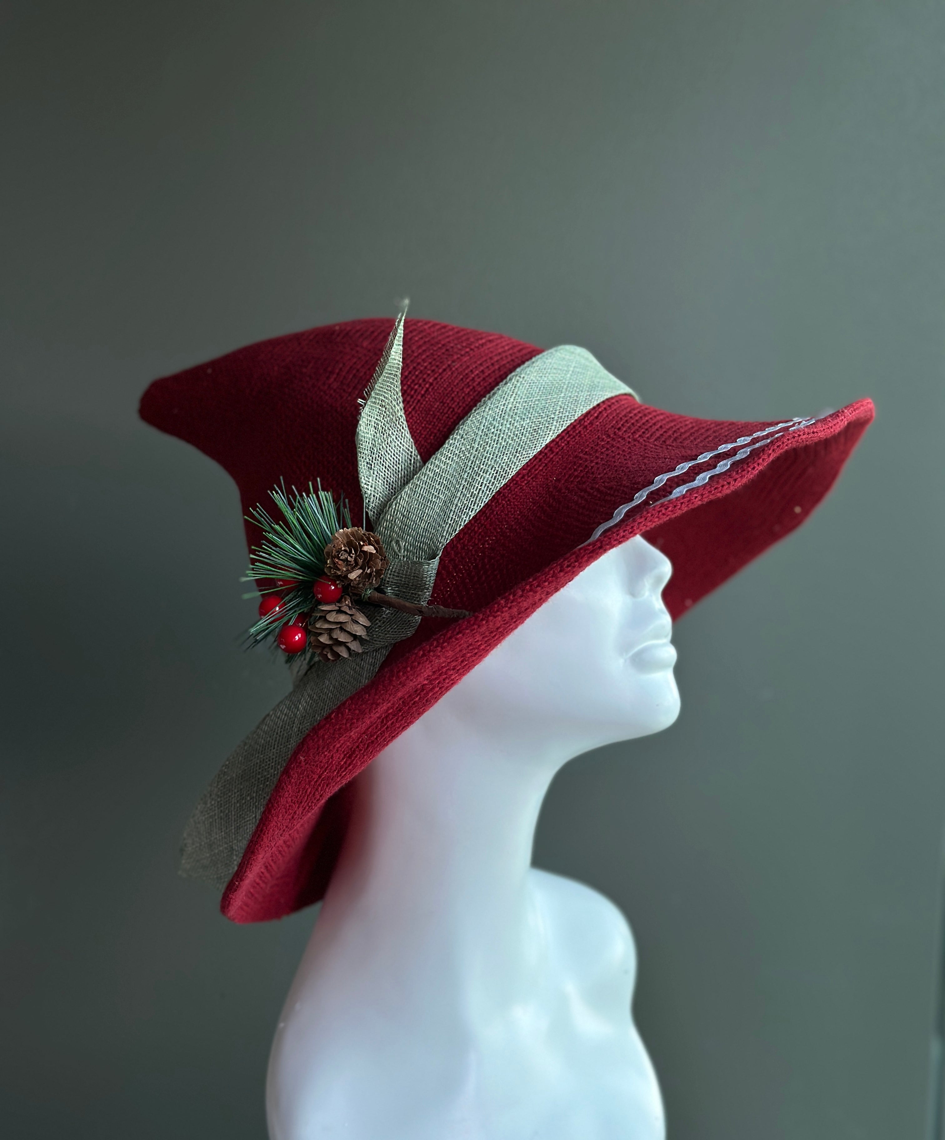 Red Christmas wide brim hat with pine greenery pinecones berries and ribbon holiday accent