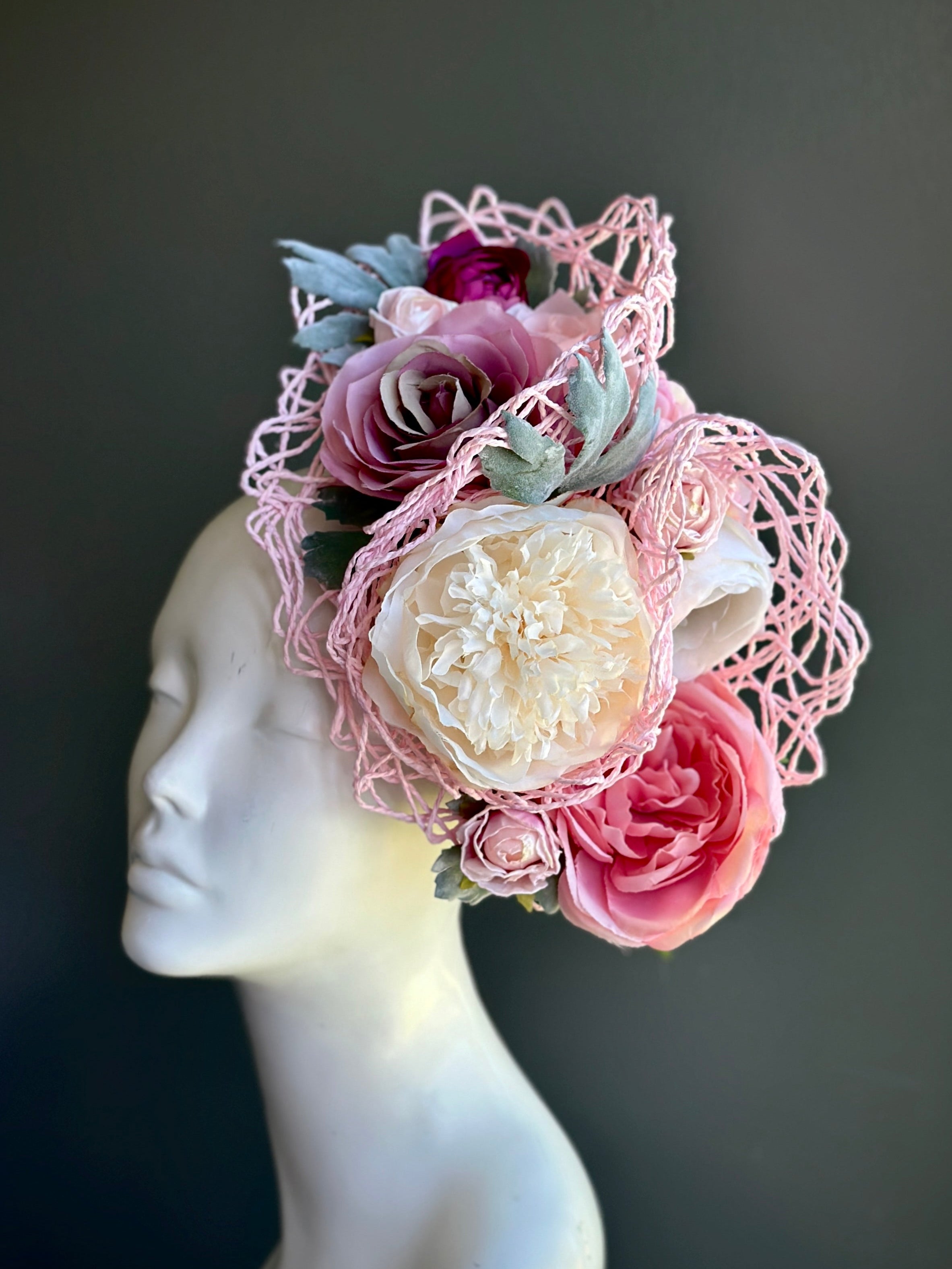 Pink rose bouquet fascinator hat with cream flowers and lace mesh on headband