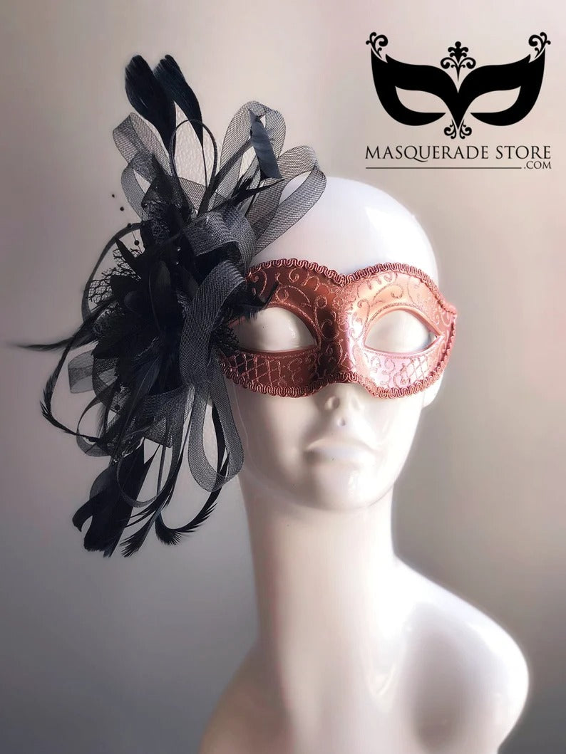 Elegant rose gold masquerade mask with black feathers and ribbon side accent, Venetian style.