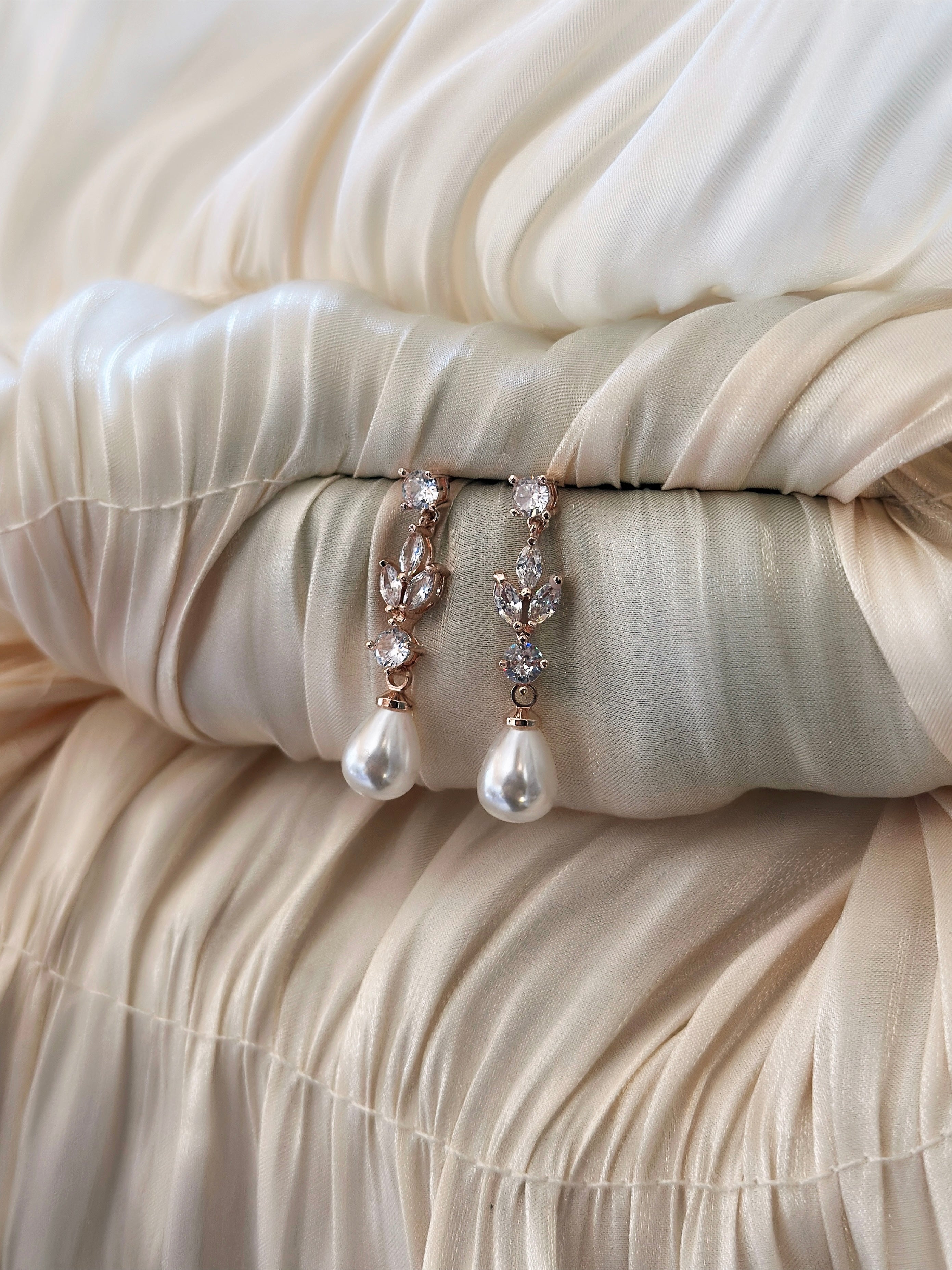 Rose gold earrings with sparkling cubic zirconia and elegant pearl accents, designed for a refined and timeless look.