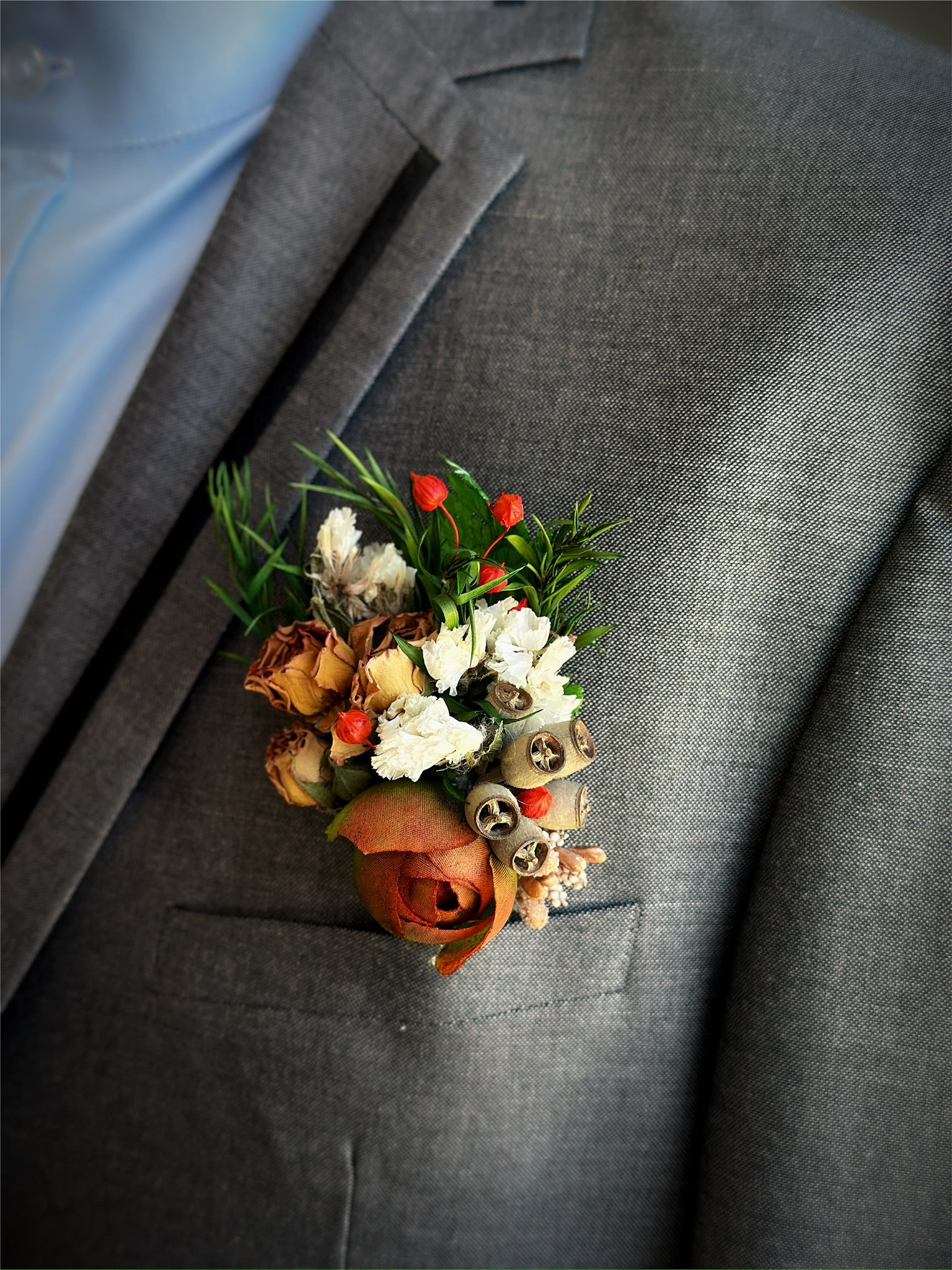 Earth-toned prom boutonniere with preserved florals and rustic greenery