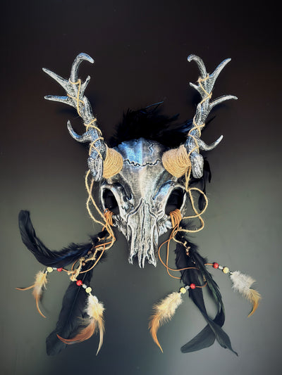 silver-black antler skull headdress with intricate detailing, black feathers, and rustic jute bindings.