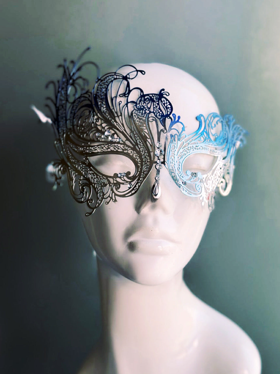Elegant silver and blue swan-inspired metal mask with intricate filigree details and shimmering rhinestones.