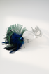 Silver filigree mask with blue and green feathers and jewel accent, designed for masquerade parties, weddings, and proms.