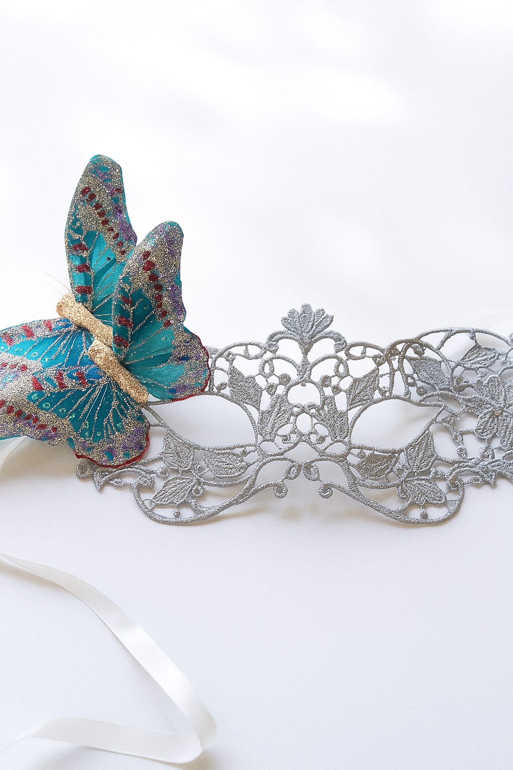Elegant silver lace masquerade mask with glittery blue butterfly accent, perfect for prom, masquerade balls, and costume events.