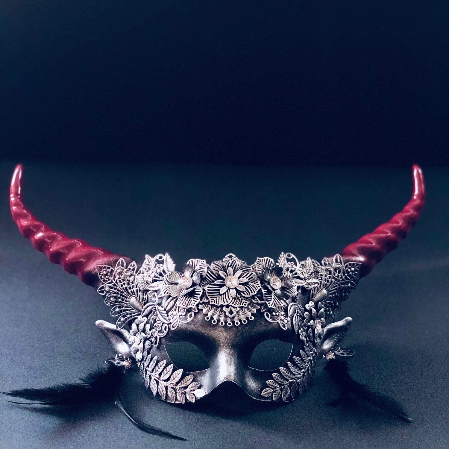 Silver and red gothic floral horn masquerade mask with black feathers