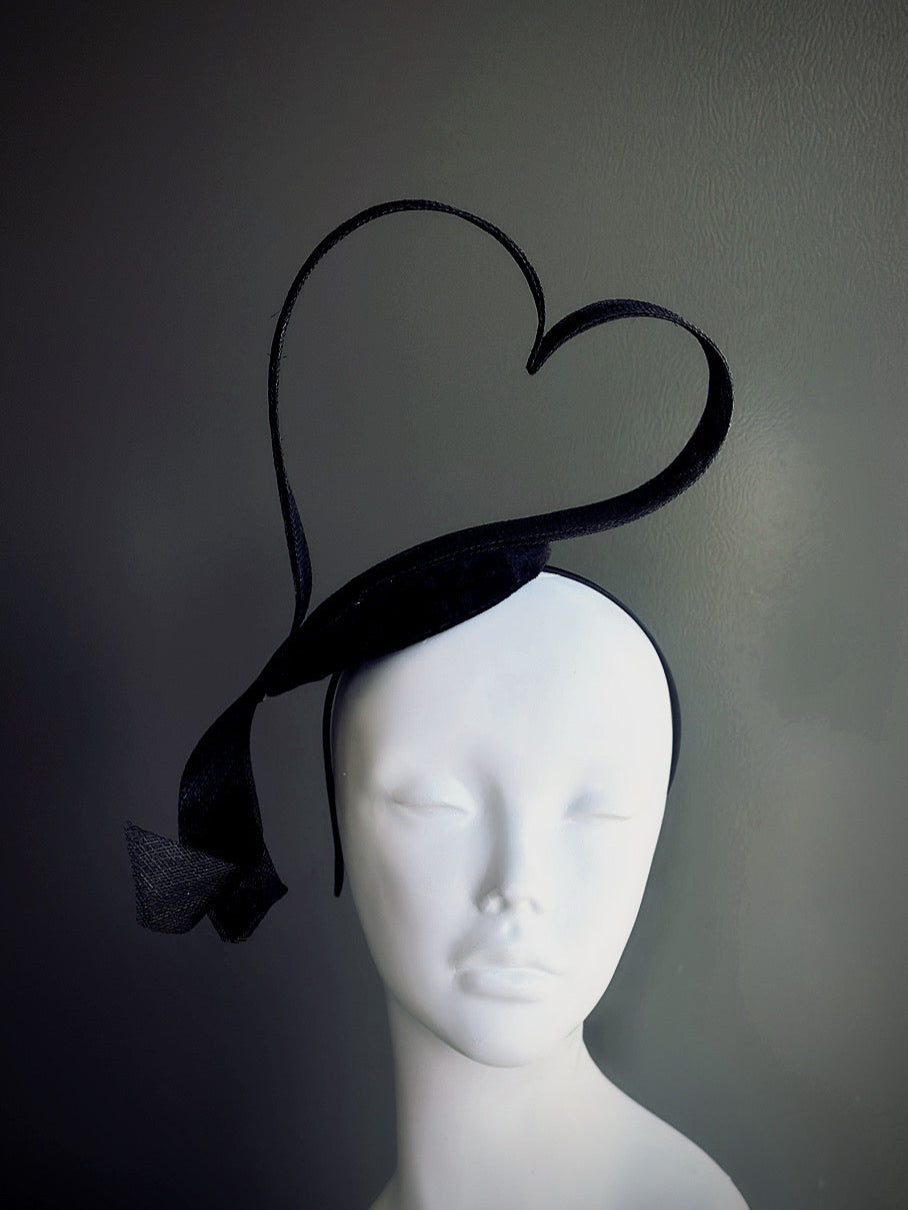 Black heart-shaped sculptural fascinator hat on headband