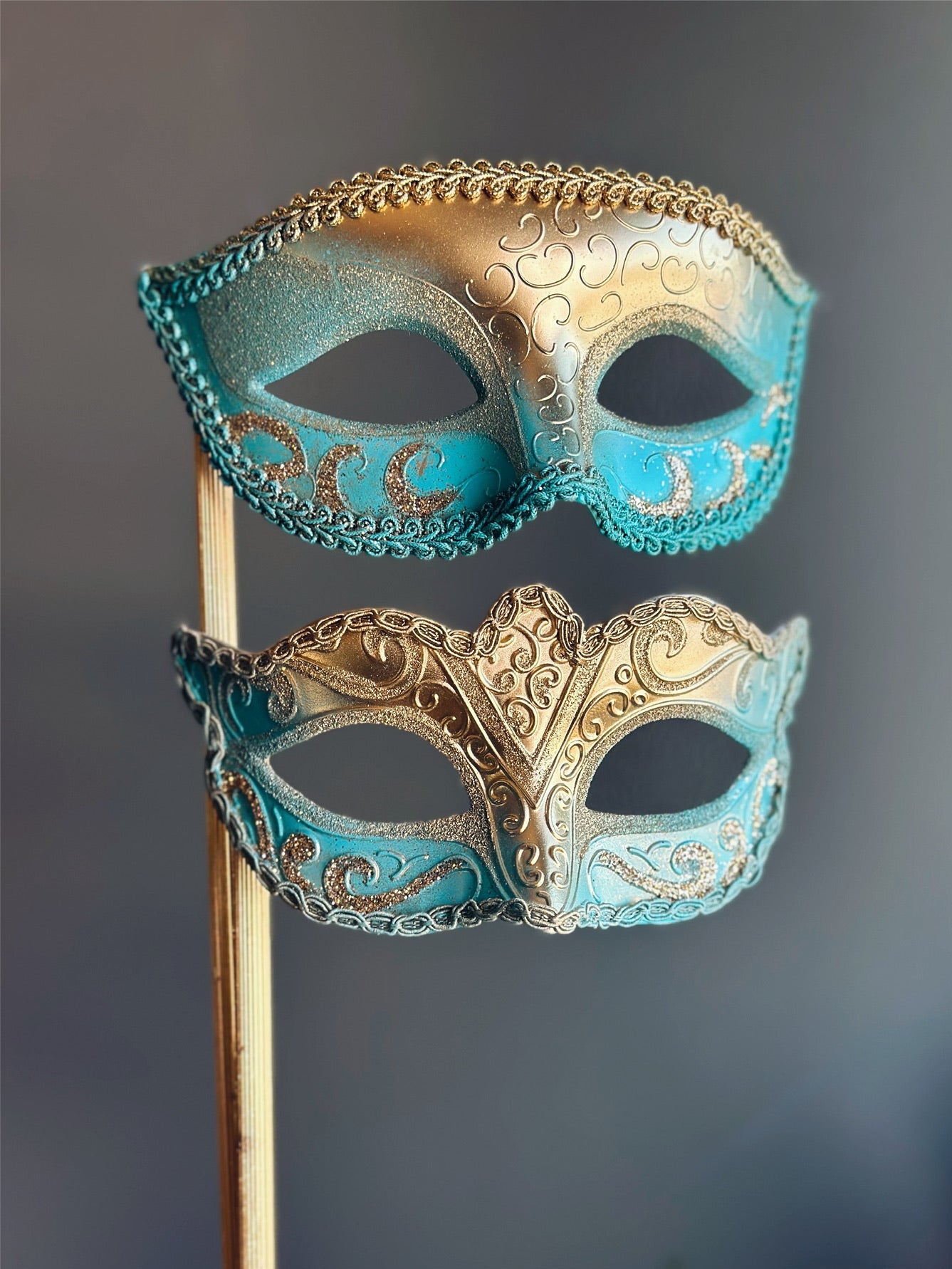 Pair of gold and turquoise handheld masquerade masks with scroll and glitter accents