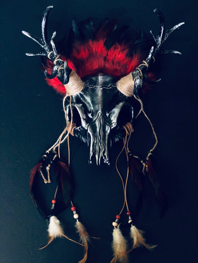 Wiccan ritual deer antler skull headdress with red feathers, twine-wrapped antlers, and intricate rustic details.