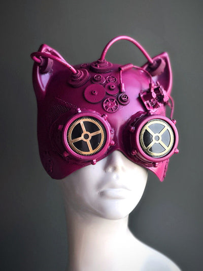 Pink steampunk cat mask with gear embellishments and metallic goggles.