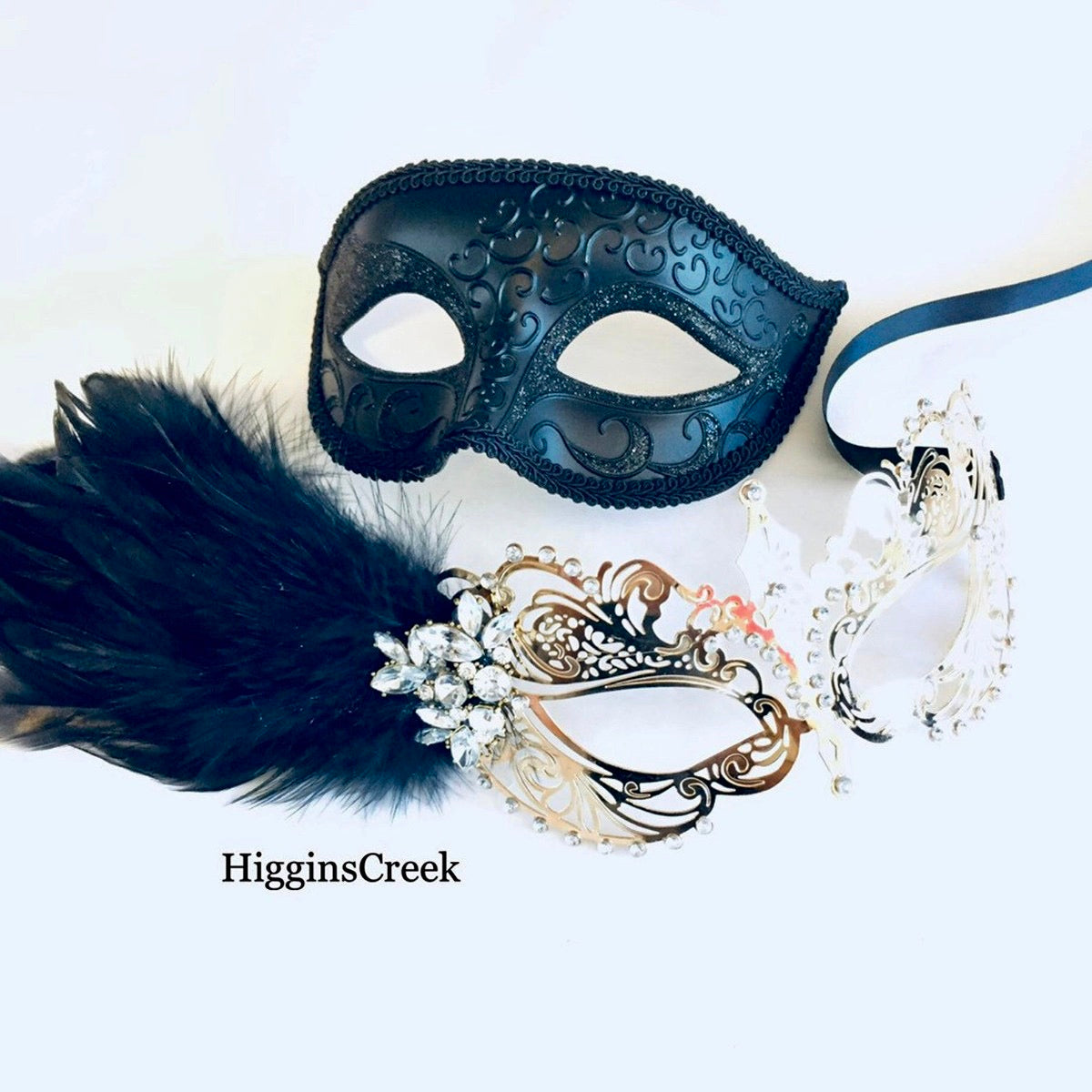 Elegant masquerade mask pair with black feather and silver metal detailing