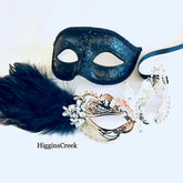 Elegant masquerade mask pair with black feather and silver metal detailing