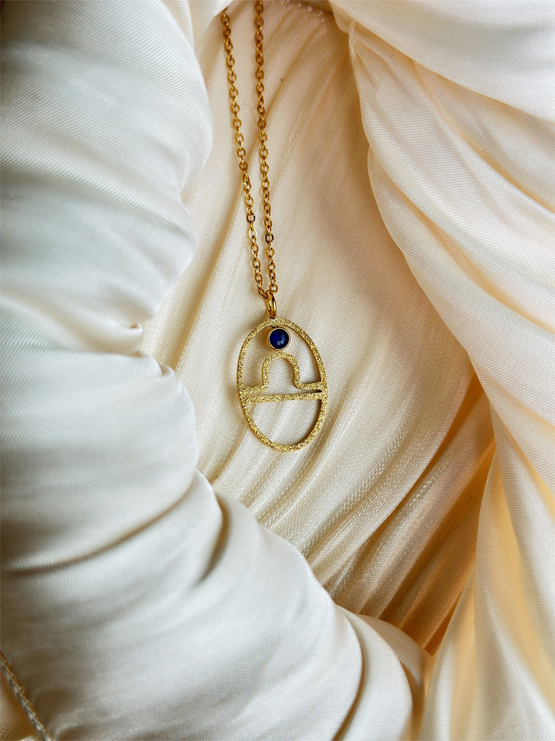 gold libra zodiac pendant necklace with blue gemstone