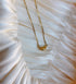Gold necklace with a single marquise-cut yellow gemstone pendant.