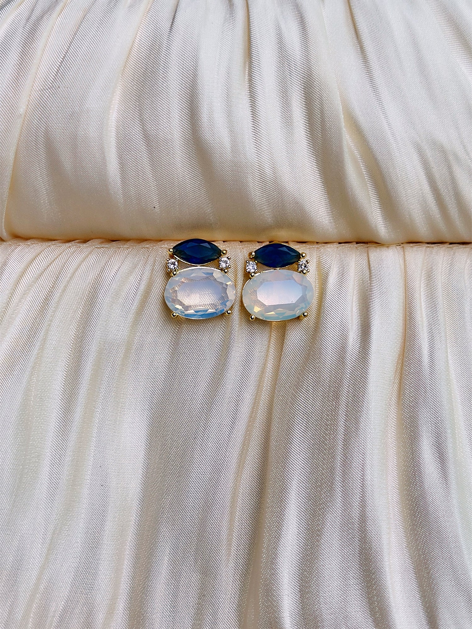 Blue and opal white gemstone stud earrings with gold setting and marquise top stones.