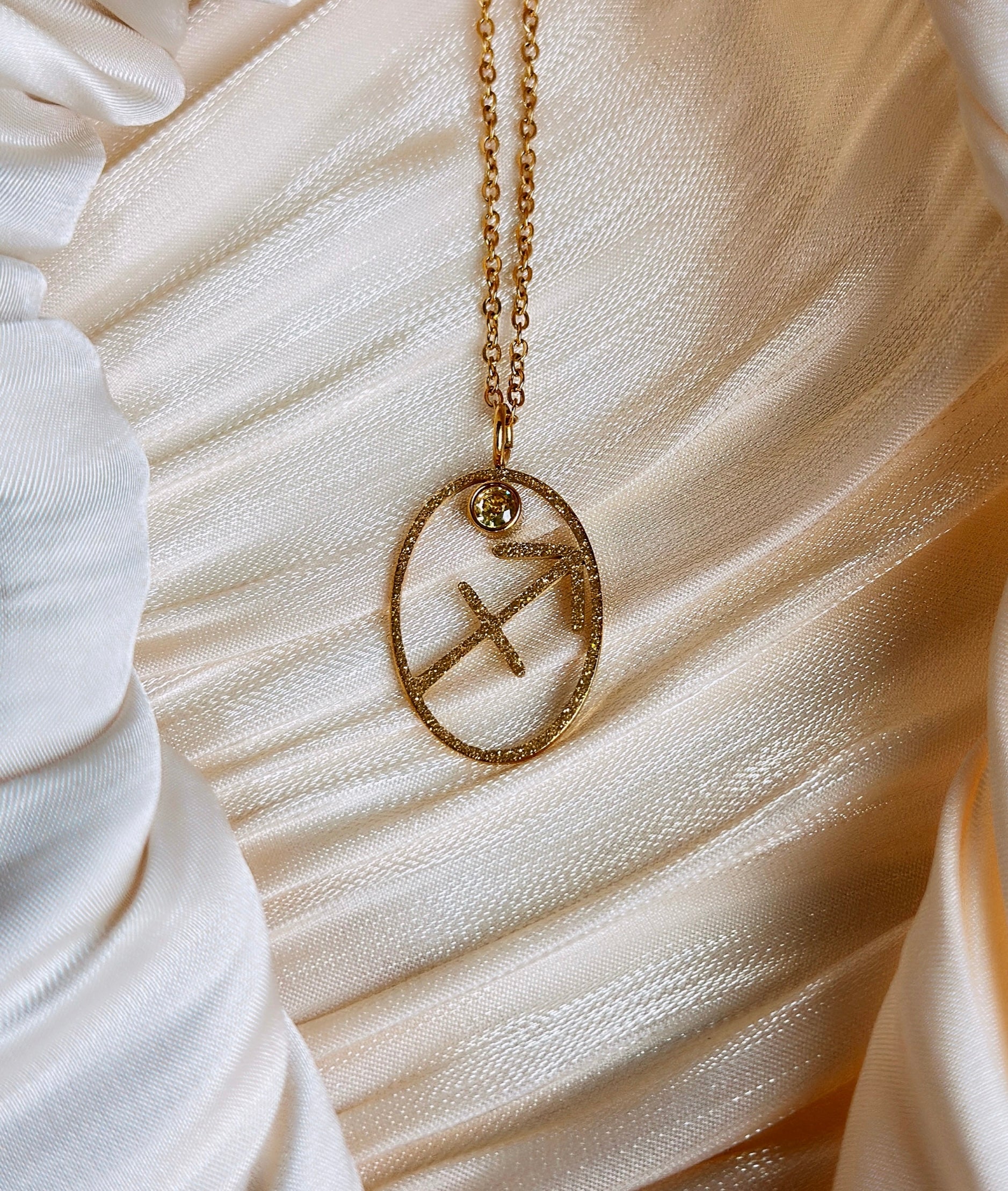gold sagittarius zodiac pendant necklace with a yellow gemstone
