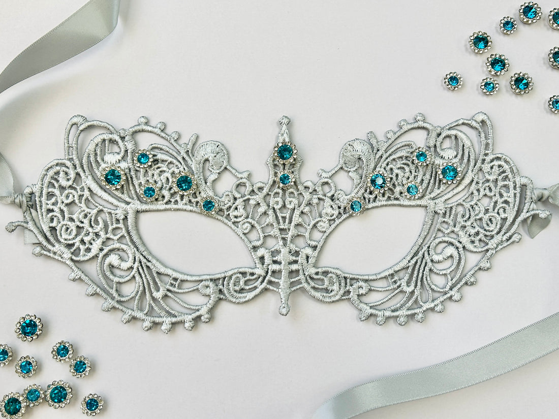 Silver lace masquerade mask with aqua blue crystals for gala parties and Venetian ballroom events.