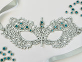 Silver lace masquerade mask with aqua blue crystals for gala parties and Venetian ballroom events.