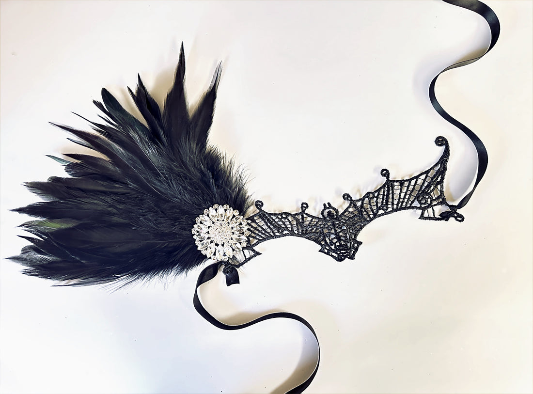 Gothic bat lace masquerade mask with feathers and rhinestone jewel for Halloween or masquerade balls.
