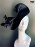 Black fascinator hat with sculptural curves and butterfly accents, perfect for Derby, weddings, races, and masquerade events.