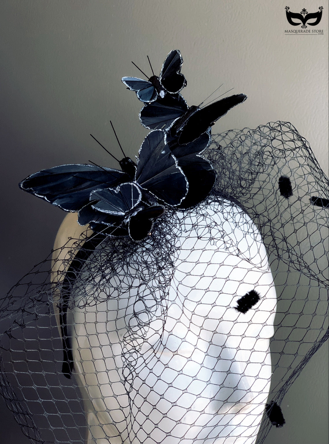 Black fascinator with butterfly accents and netted veil, perfect for Derby, weddings, masquerade balls, and races.
